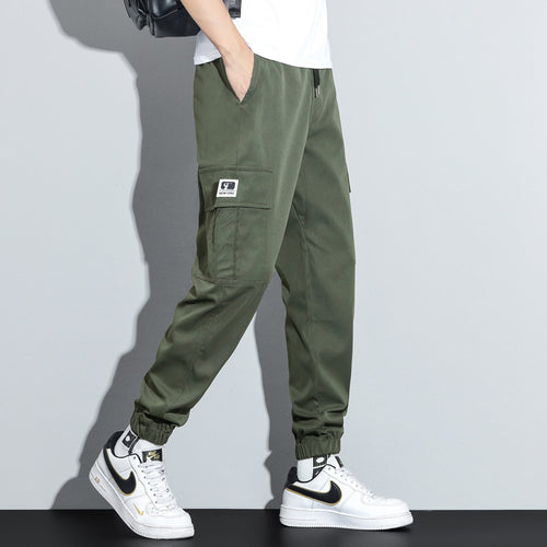 Person wearing green cargo pants with a white background