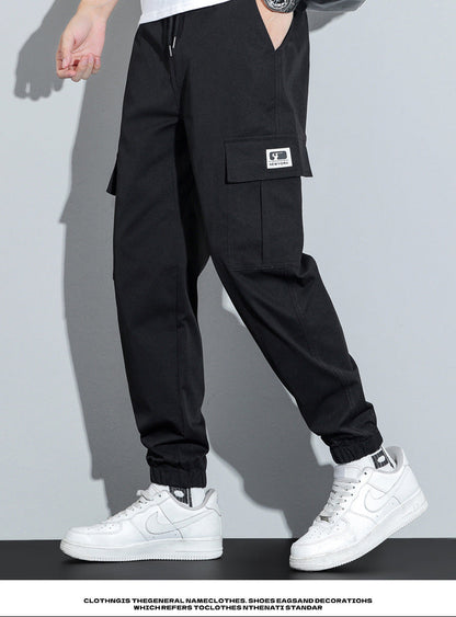 Person wearing black cargo pants with a white background
