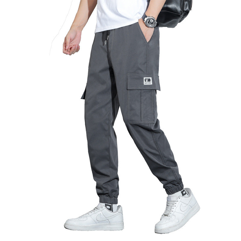 Person wearing gray cargo pants with a white background